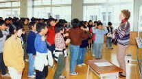 Karen teaches a song to the 100 fifth-graders of Ayagaoka Grade School